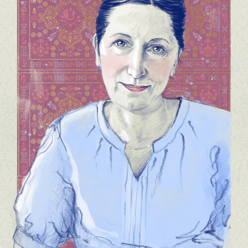 Portret Alicji Kulik w błękitnej bluzce. W tle tapeta we wzory warmińsko-mazursko-indyjskie